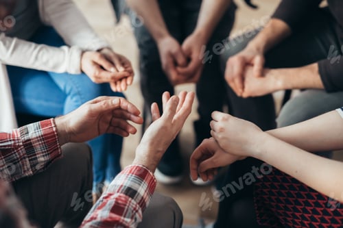 Preview: Close-up of hands of people sitting in a circle during a therapy group meeting