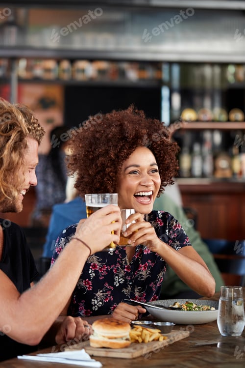 Preview: Couple On Date Meeting For Drinks And Food Making A Toast In Restaurant
