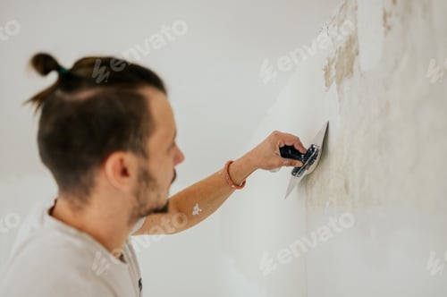 Preview: Close up of a builder skim coating and plastering wall with plaster.