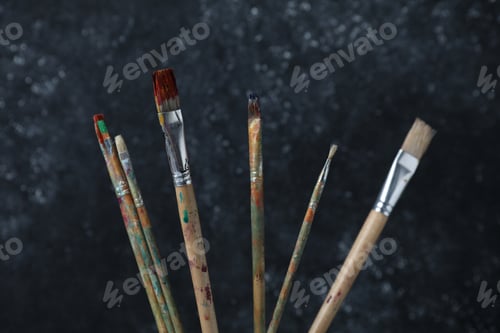 Preview: Many dirty paintbrushes on black background, closeup