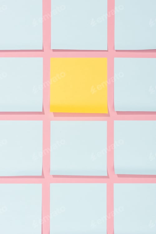 Preview: elevated view of empty blue and yellow stick it notes on pink