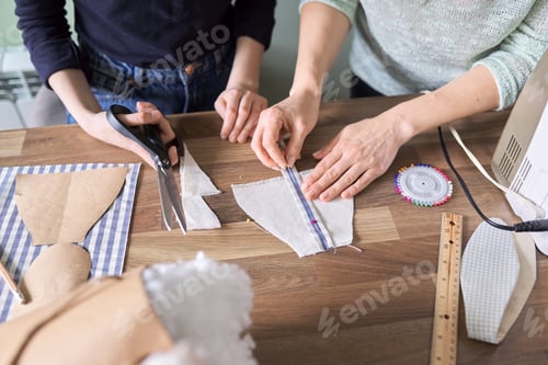 Preview: Sewing process close-up. Hands of woman and daughter sewing