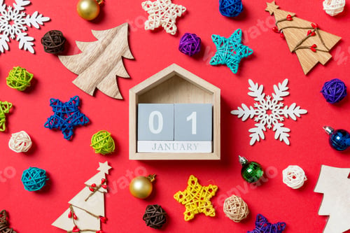 Preview: Top view of calendar on red background made of holiday decorations and toys.
