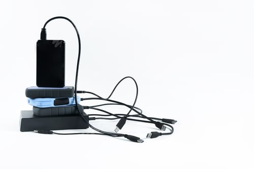 Preview: many external hard drives with wires lie on a white background. Hard drives on isolate.