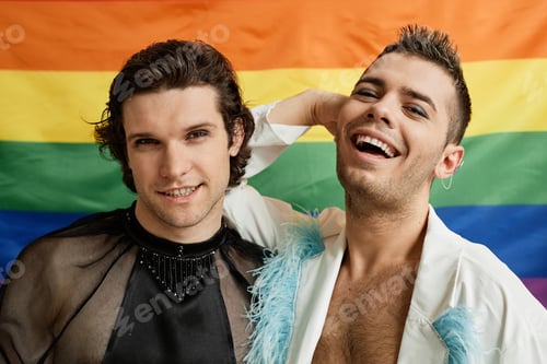 Preview: Two gay young men posing with LGBTQ pride flag in background