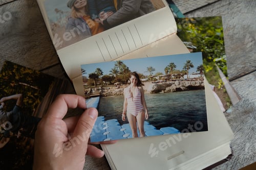 Preview: Photo printing concept. Person looks at printed photos in photo album.