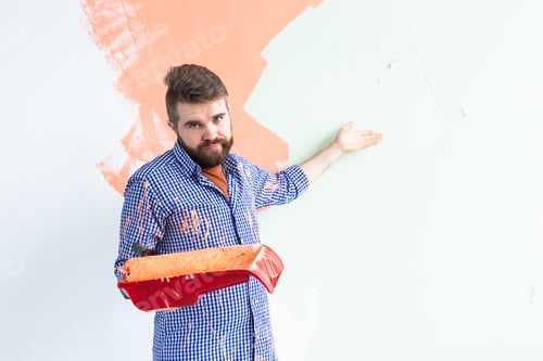 Preview: Funny man painting interior wall of home. Renovation, repair and redecoration concept