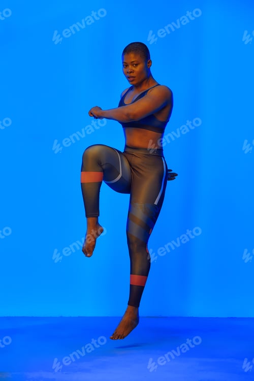 Preview: Happy african american woman wearing sportive clothes showing plus size hips. Body positive concept