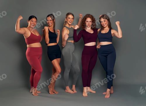 Preview: Group of happy five young women showing strength in sports clothes