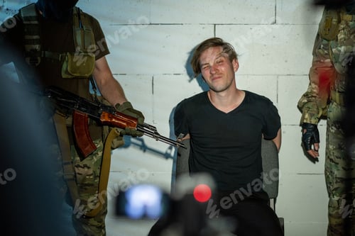 Preview: Cyber criminal sitting by wall between two soldiers