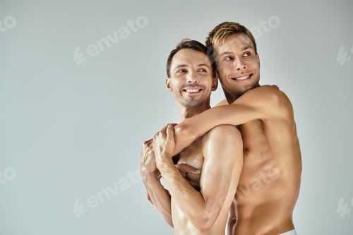 Preview: Joyful young couple sharing a heartfelt embrace in a minimalistic indoor setting