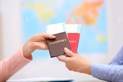Preview: Female manager giving passports with tickets to client in travel agency, closeup