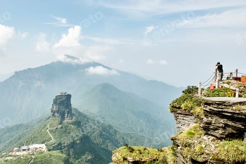 Preview: A solitary figure gazes at a majestic mountain vista from an overlook