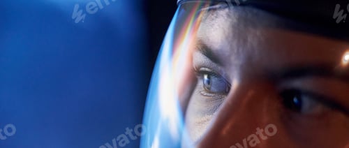 Preview: Close up view of woman in glassed space helmet against blue background