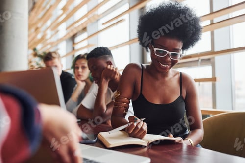 Preview: Black woman sitting in front of group of multi ethnic people with alternative girl with green hair