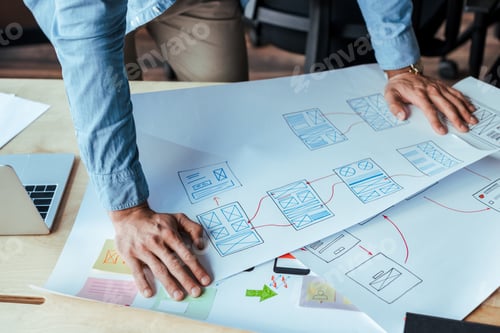Preview: Cropped view of UI designer with wove papers at table
