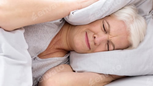Preview: Upset senior woman closing her ears with pillow