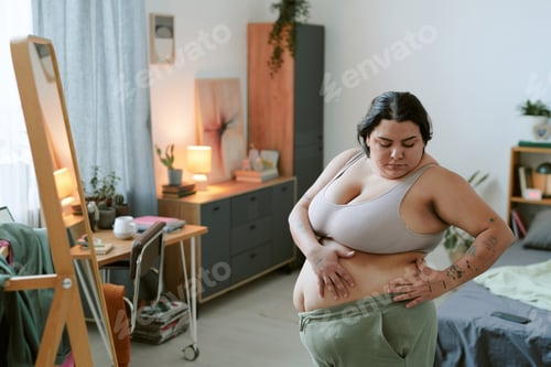 Preview: Woman Adjusting Workout Clothes in Cozy Bedroom