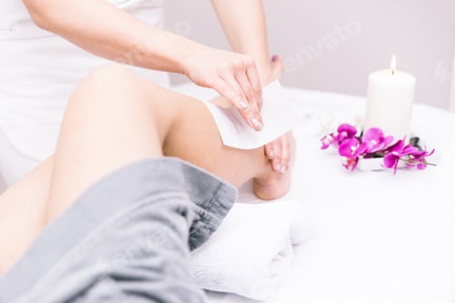 Preview: Woman making waxing on her legs in a beauty saloon