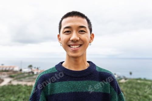 Preview: Portrait of happy young Asian teenager smiling in front of camera