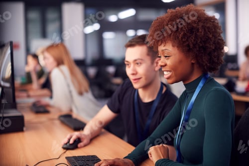 Preview: Group Of College Students Studying Computer Design Sitting At Line Of Monitors In Classroom