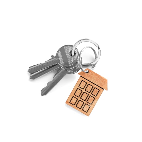 Preview: House keys with trinket on white background, top view