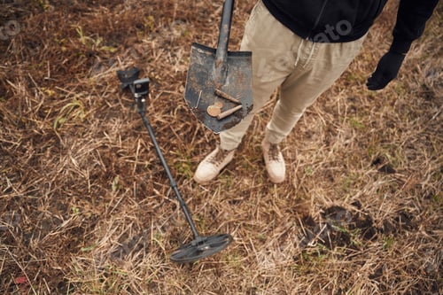 Preview: Old bullets and coin. Man is with metal detector in the field