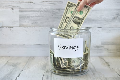 Preview: Dollar Bills Being Placed into a Savings Jar