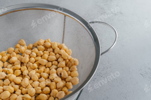Preview: Organic seeds in sieve. Dry chickpeas for healthy eating. Overhead view. Nutrient dense food.