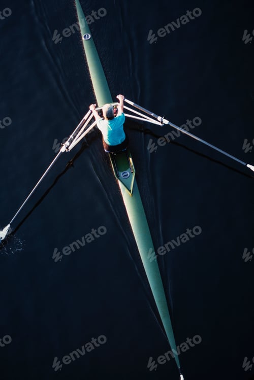 Preview: A man sculling in a single scull rowing boat, on the water. Overhead view.