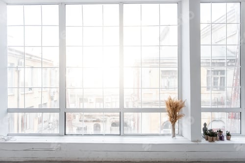 Preview: Glass vase with pampas grass dried reeds stands by large panoramic window on white wooden windowsill