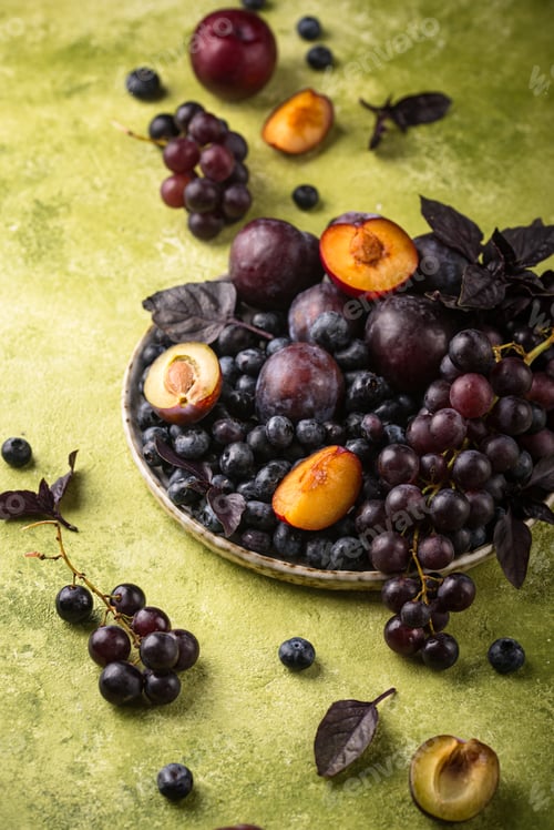 Vista previa: Assortment of purple fruit plum, grape, blueberry and basil