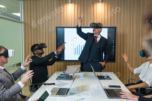 Preview: Businesspeople wearing VR goggles while working.
