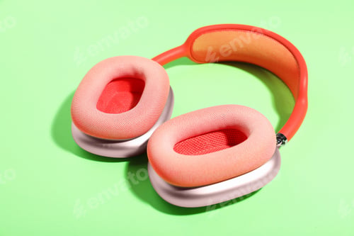 Preview: Pair of stylish pink headphones on light green background
