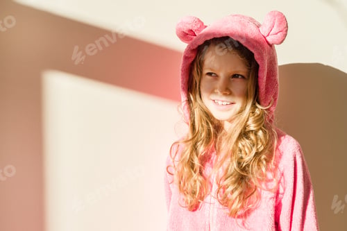 Preview: Portrait of a girl in soft warm pink pajamas.