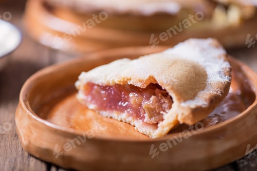 Preview: Piece of fresh rhubarb and strawberry pie with cream nearby