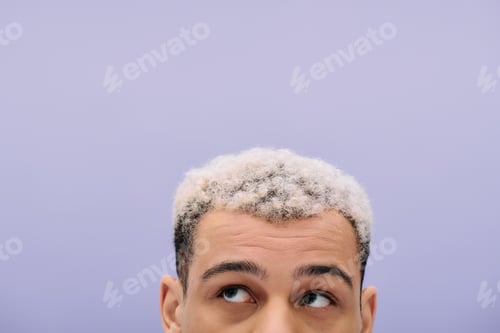 Preview: Stylish young man showcases trendy fashion against a vibrant purple backdrop