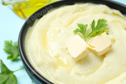 Preview: Mashed potatoes with butter in bowl on blue background, close up