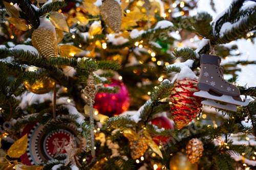 Preview: beautiful multi-colored toys on a Christmas tree against the background of lights and snow
