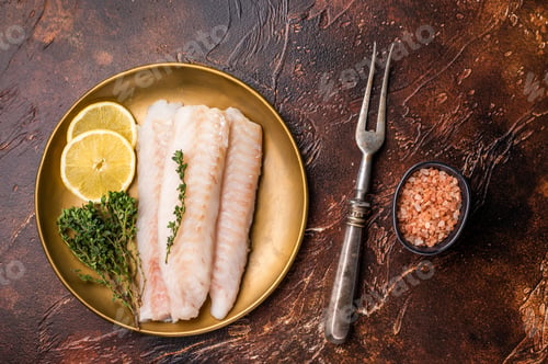 Preview: Raw cod loin pieces, whitefish fillets without skin on plate with herbs. brown background. top view