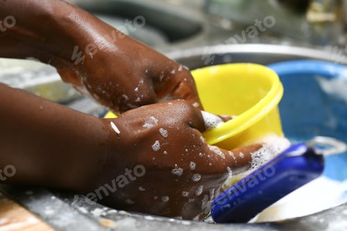 Preview: Closeup shot of a black female hand washing a yellow bowl