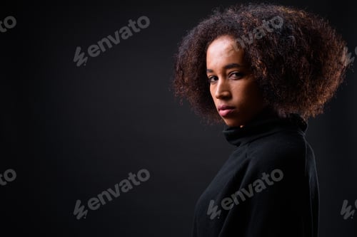 Preview: Young beautiful African woman with Afro hair against black background