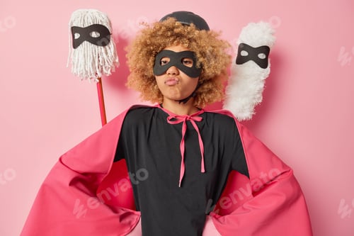 Preview: Routine home work and housekeeping concept. Self confident brave woman pretneds being superhero keep