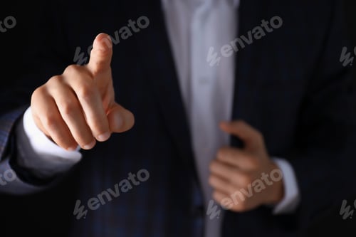 Preview: Man in suit and hand on dark background, close up