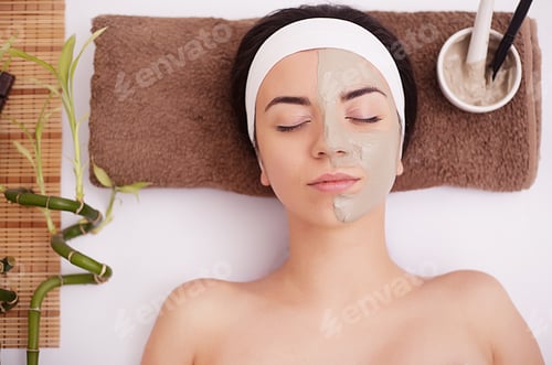 Preview: Hands of therapist apply cream to face of woman. Concept of care and youth