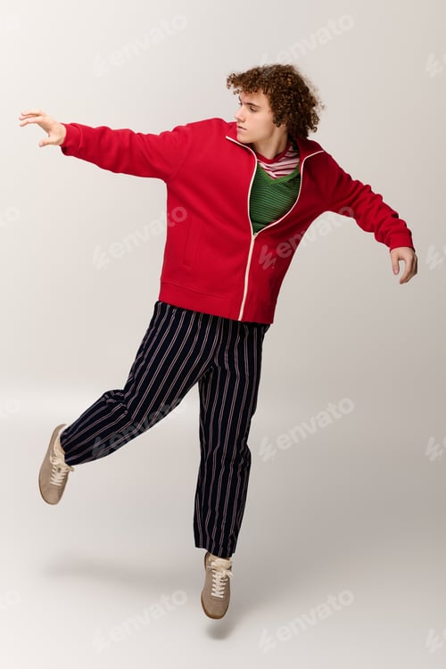 Preview: Teenage boy showcasing dynamic fashion in a vibrant studio setting