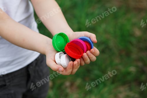 Preview: A little girl holds plastic bottle caps in her hands. Volunteer charity event "Good lids