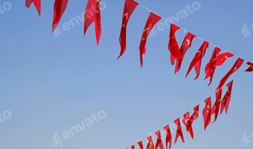 Preview: Many Turkish flags hanging at street against blue sky, ready to national holiday celebration.