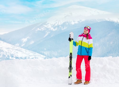 Preview: Young happy girl holding ski at mountain ski resort