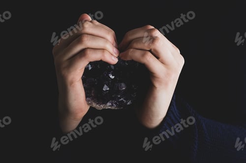 Preview: Hands holding purple amethyst crystal